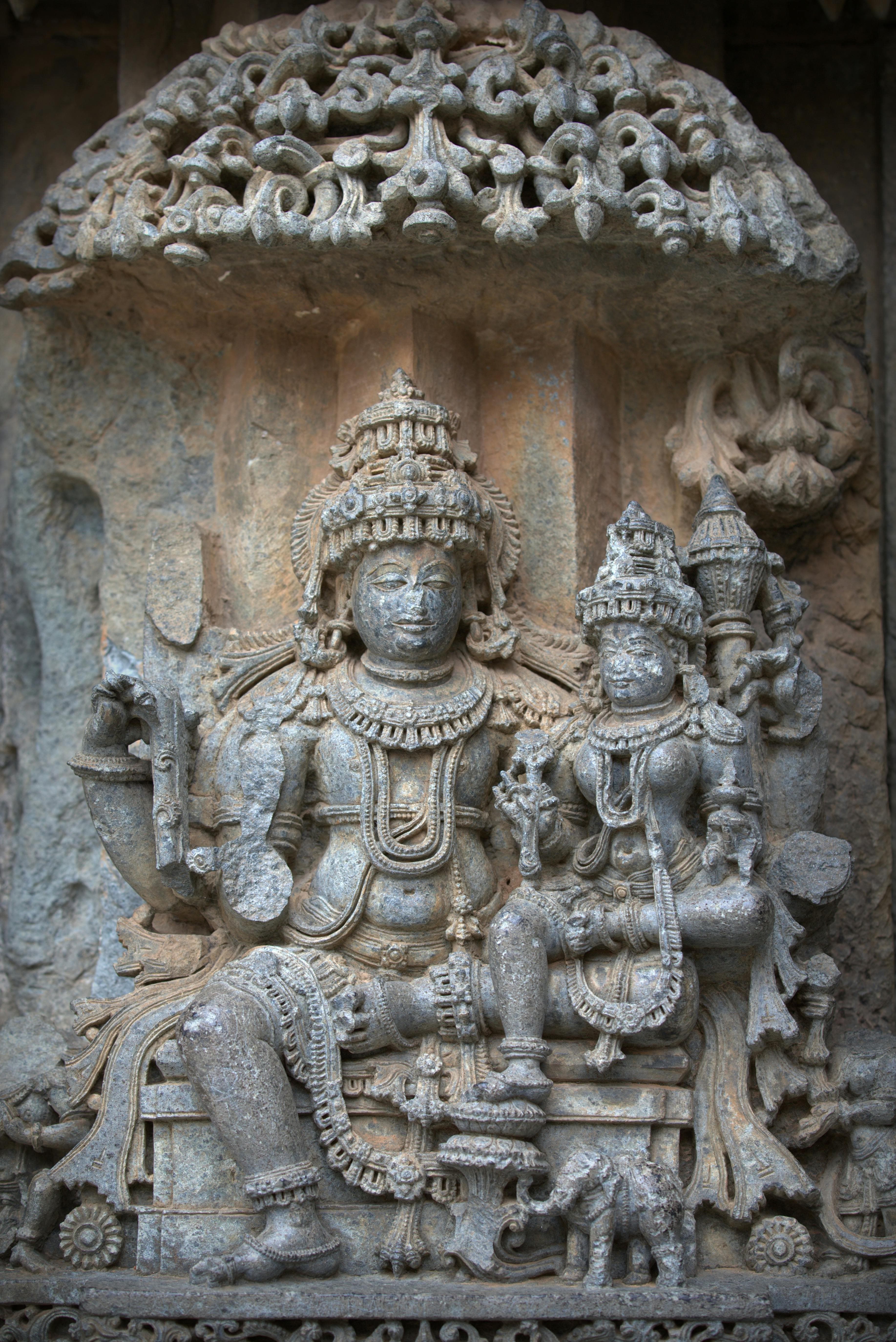 Ancient Hindu temple with intricate stone carvings undergoing restoration